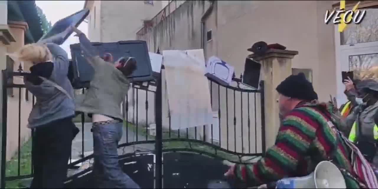 Des manifestants jètent leur écrans de TV devant un institution publique
