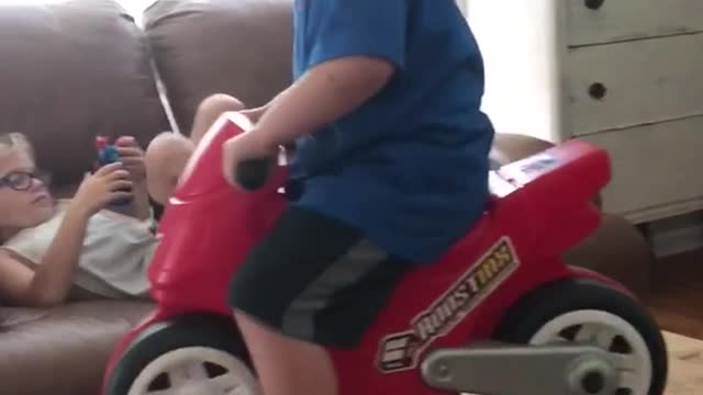 Little boy blue shirt red motorcycle falls off table