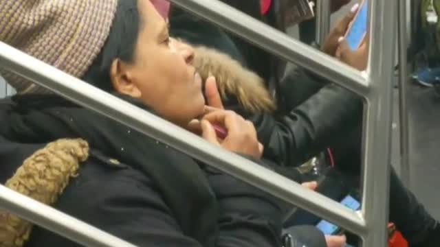 Woman pulling chin hair subway wearing beanie