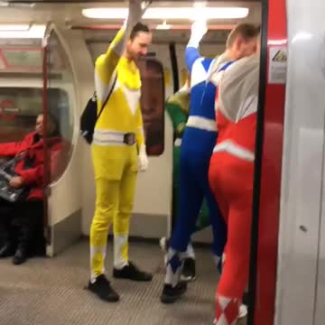 Four men dressed as power rangers on train