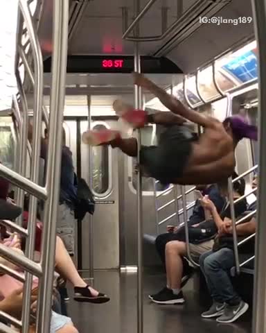 Shirt guy black shorts purple bandana dancing on pole subway