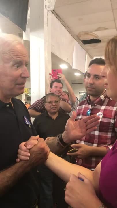 Biden takes hand of Iowa teacher