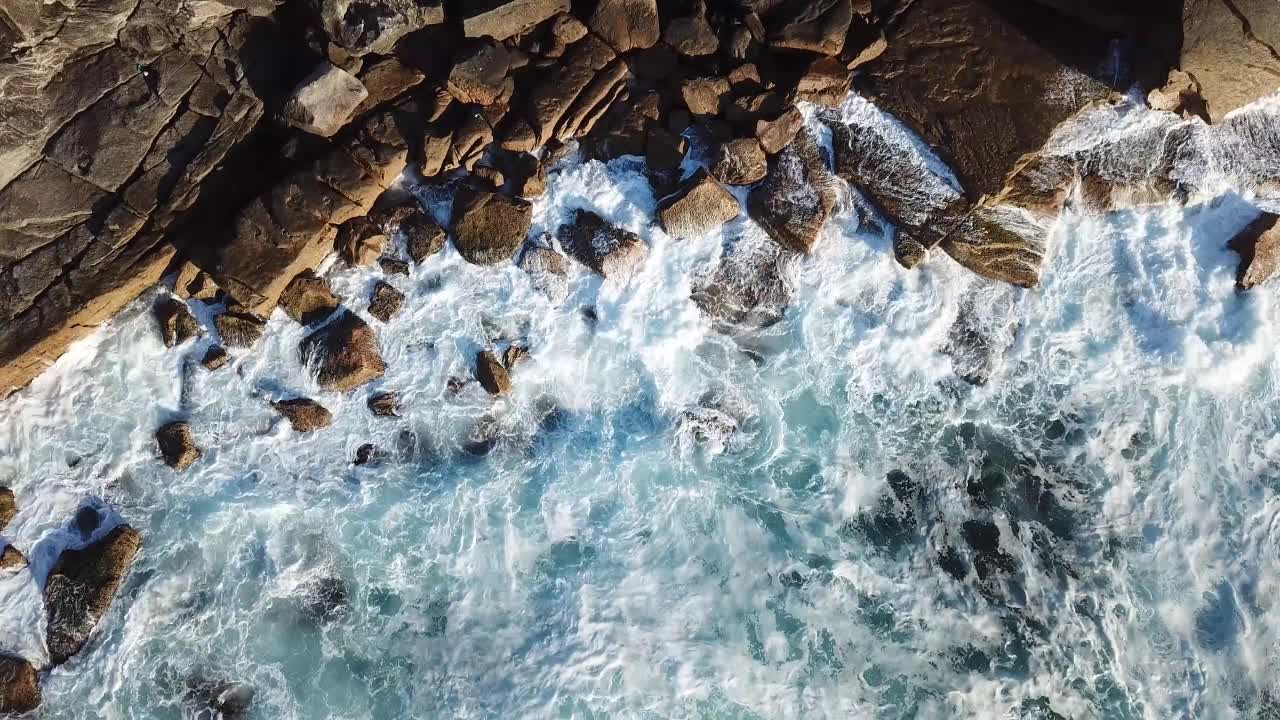 The sound of the waves breaking on the rocks