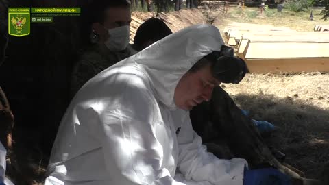 Captured Ukrainian soldiers in burial of their fellow soldiers...