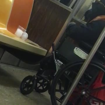 Man in wheelchair smokes cigarette inside subway