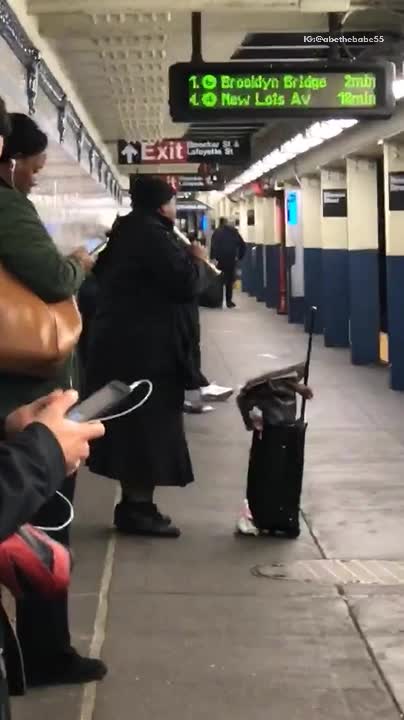 Man in black beanie plays recorder in subway terminal