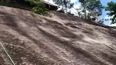 Monk walks up a steep mountain