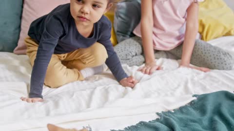 Kids Petting A Cat On The Bed