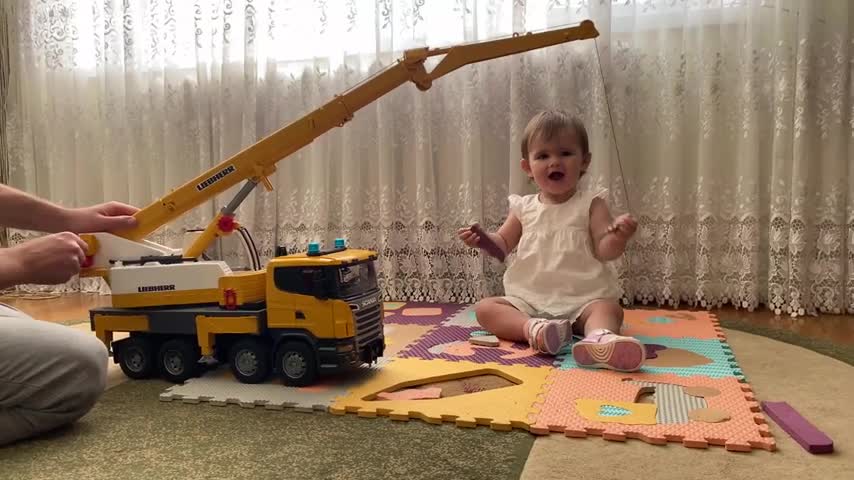 Cute_baby_and_her_dad_are_having_fun_playing_with_a_new_toy