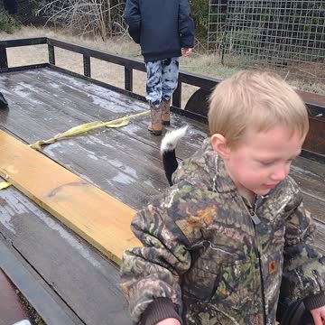 Kids playing with beagle on a frozen trailer.
