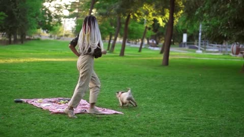 Happy, young woman having fun with her dog outdoors