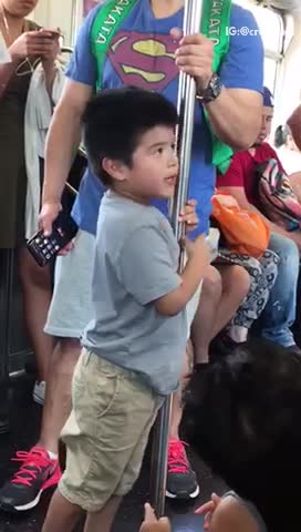 Little boy grey shirt licking subway pole train