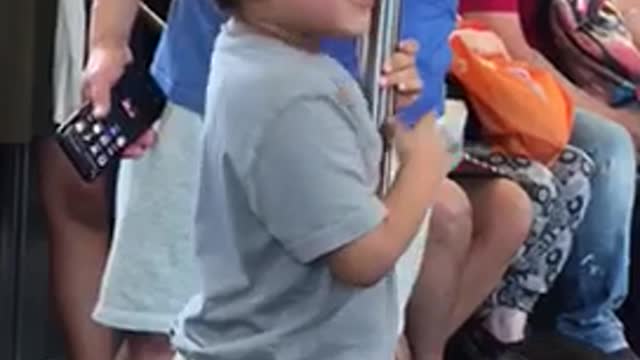 Little boy grey shirt licking subway pole train