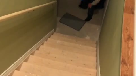 Guy slides down stairs with towel cape