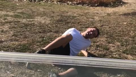 Guy in black shorts on ground after friends hits him golf cart