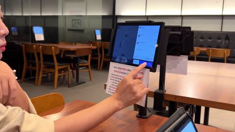 a person who orders food from a table tablet in a restaurant