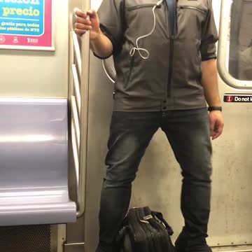 A man in blue shirt headphones dances on subway