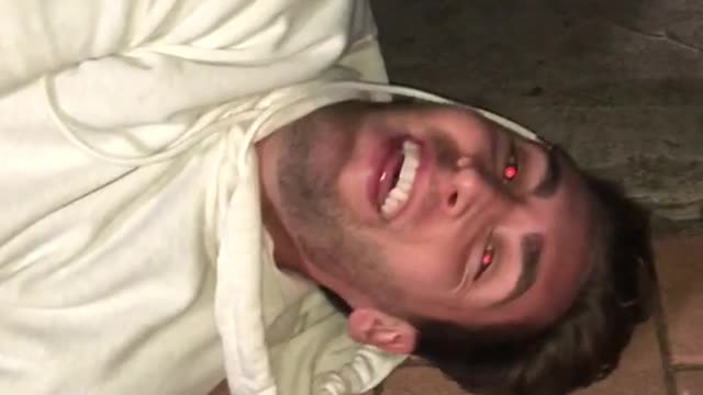 Guy falls off skateboard and hits his head on a yellow fire hydrant