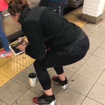 Girl frozen squatting in front of coffee in front of subway