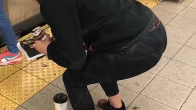 Girl frozen squatting in front of coffee in front of subway