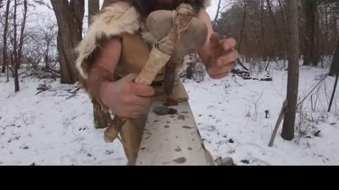Making an axe from stones in the snow
