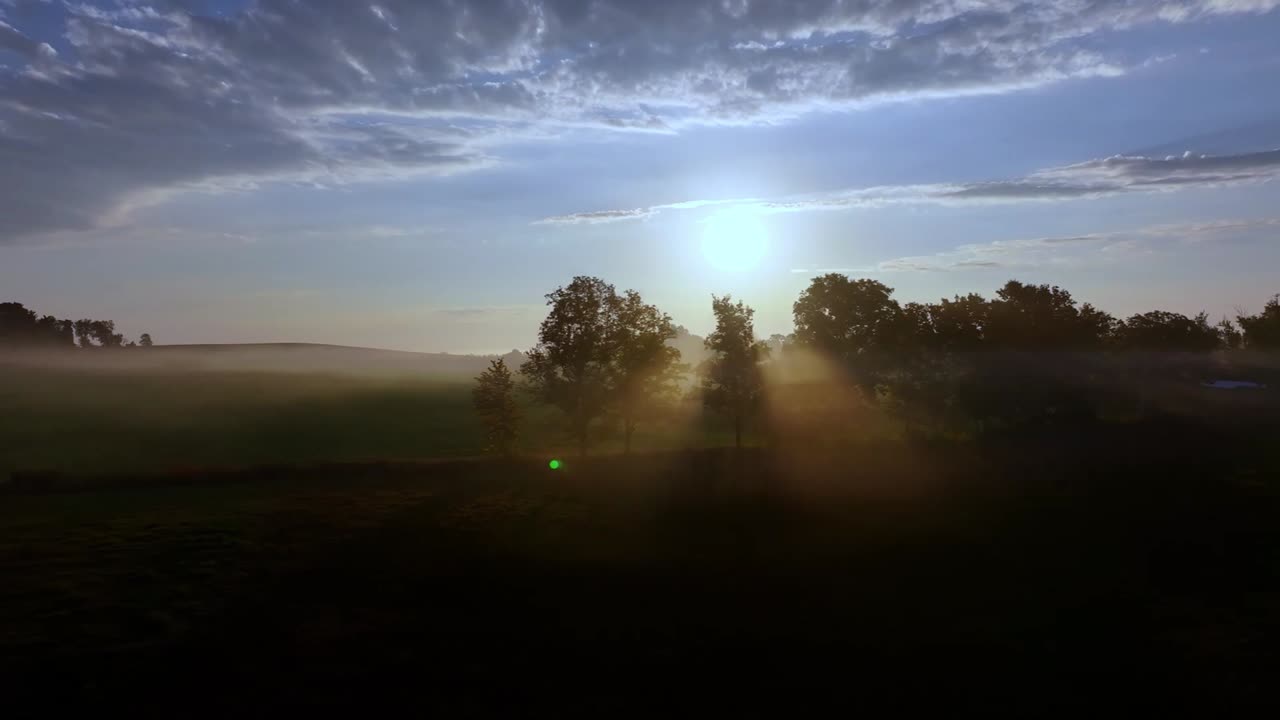 Beautiful mist enshrouds farmland at sunrise, captured from the air