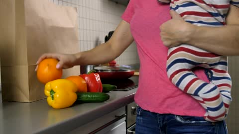 Mom with her baby in her hands starts cooking