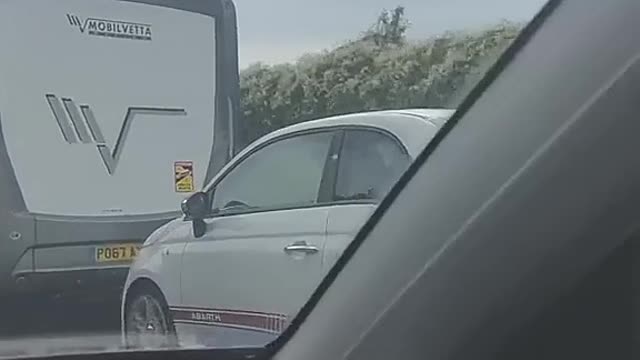 An automobile towed on the highway.