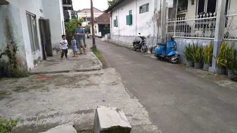 the excitement of small children playing soccer together in front of the house