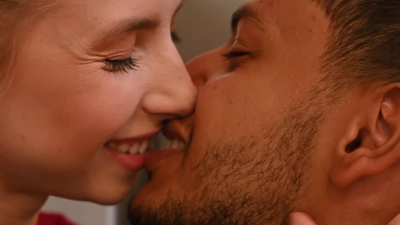 Cute couple lying on bed and kissing at home in bedroom