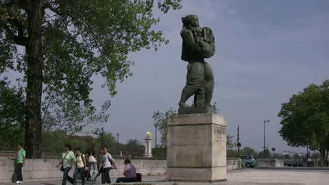 Paris people walk by statue