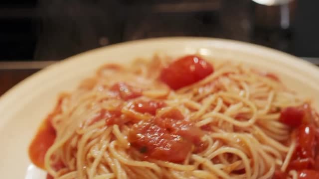 Watch a video of cooking noodles and tomatoes mixed together