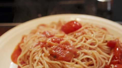 Watch a video of cooking noodles and tomatoes mixed together