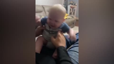 Dad makes baby laugh by tickling him and making funny sounds, cute and funny