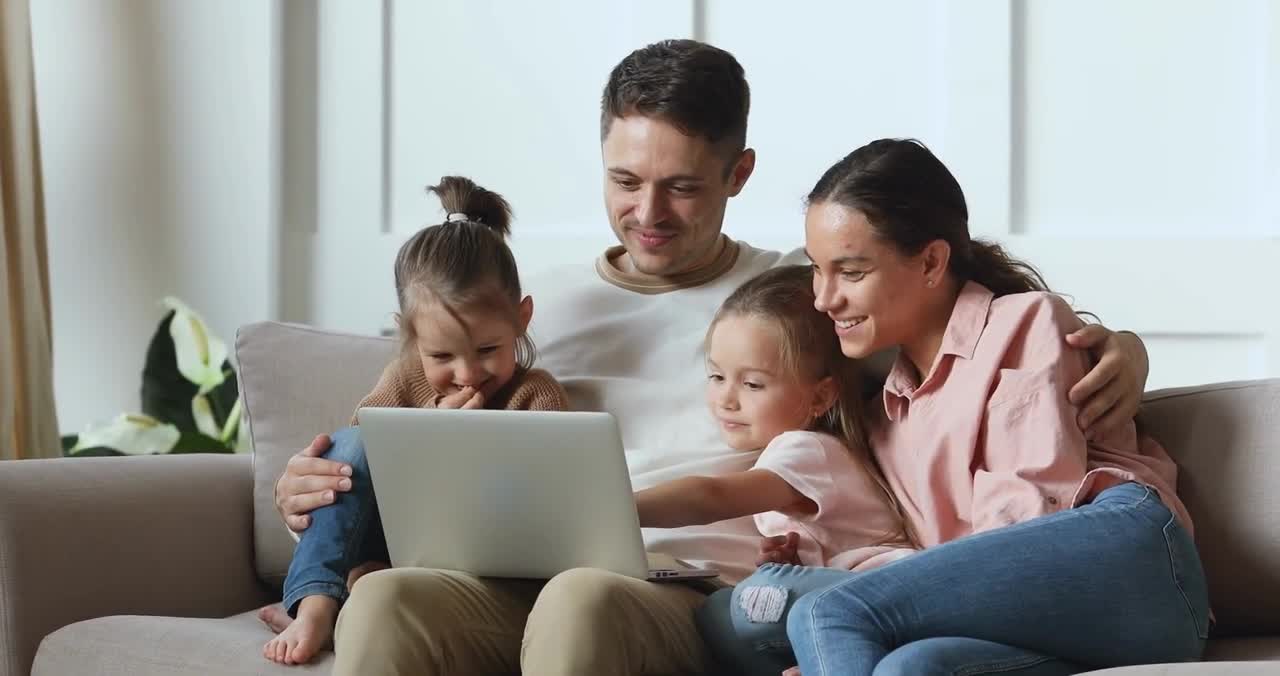 happy family couple watching funny movie cartoons with children Using Personal Computer Laptop
