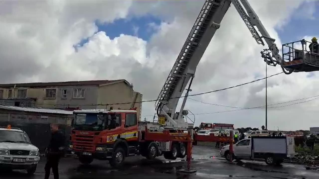 A fire truck crane moves over the damaged homes in Hanover Park.