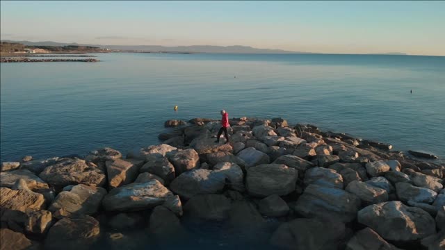 ws slo mo ts pov man walking on groyne rosignano livorno italy