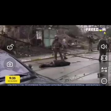 Ukrajna.Ukrán katonák az utcán holttesteket helyeznek el