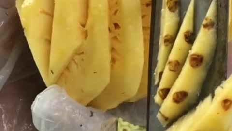 Cutting Pineapple in a Market Place