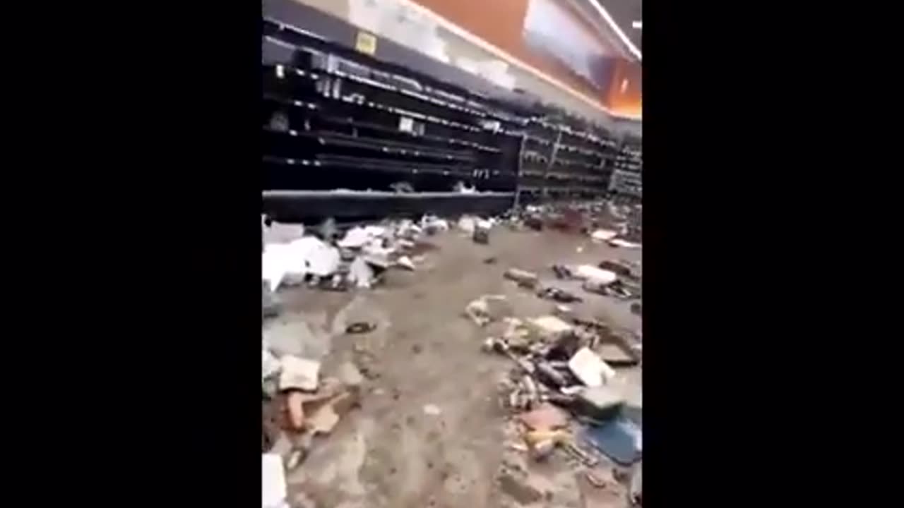 A Woman Walks Around A Looted Jewel-Osco Store