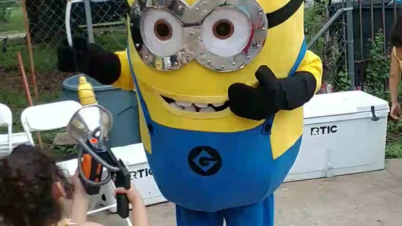 Houston mascot party character yellow helper minion plays banana vacuum game at birthday