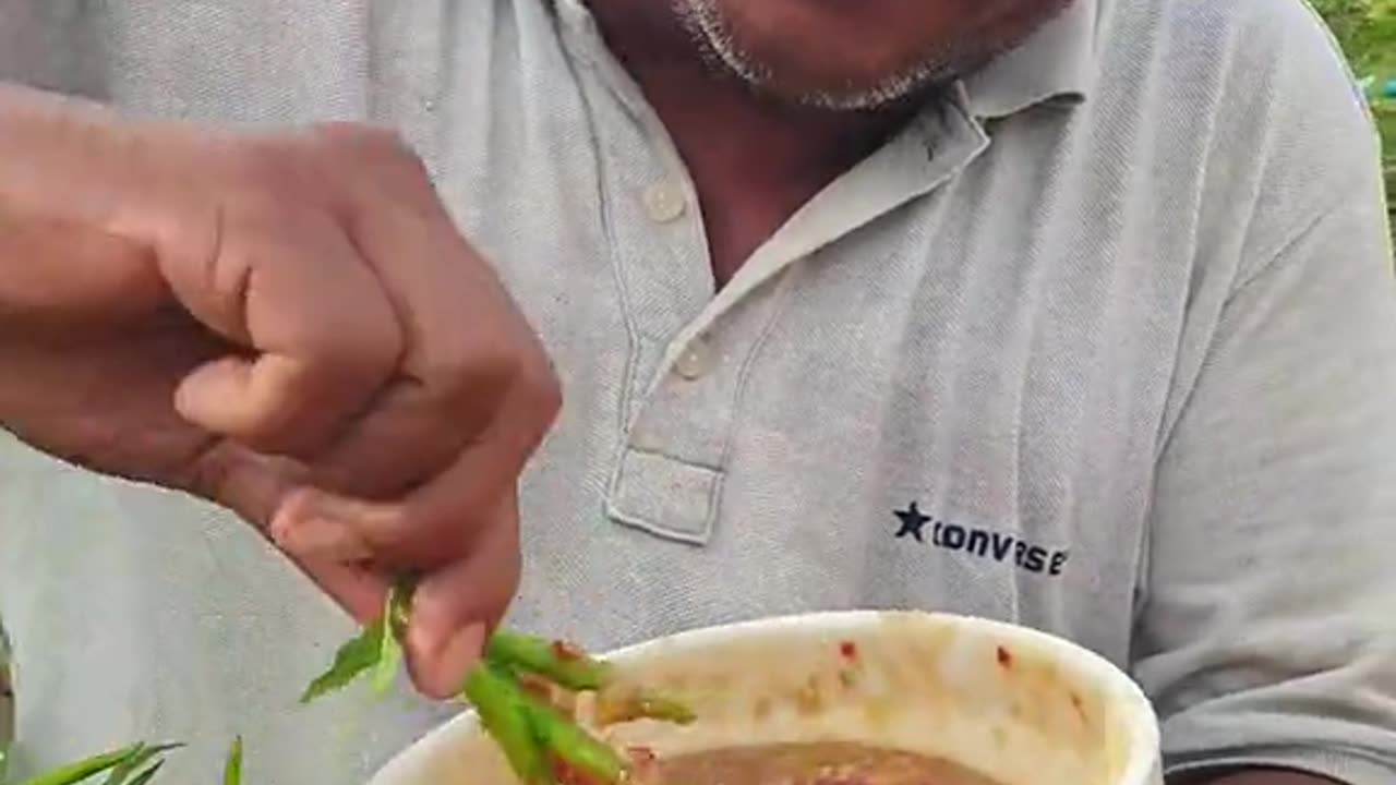 A man eating green chili