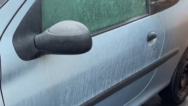 Cleaning a frozen window with a hammer