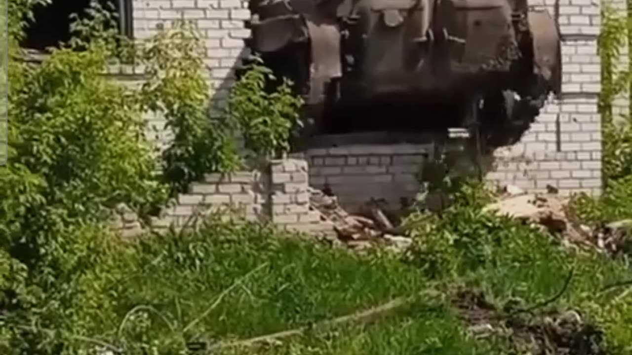 Ukrainian tank drives through a house