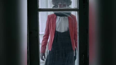 Creepy clown with bloody hand on windows glass