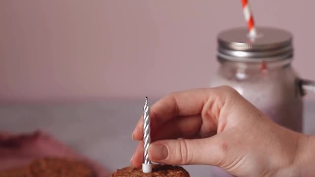 A Person Lighting a Candle on Top of the Cookie Sandwich