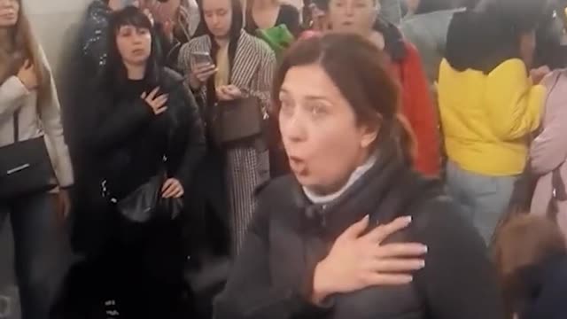 Ukrainians sing national anthem whilst sheltering under a subway station