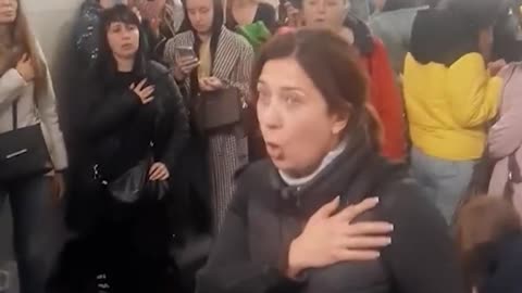 Ukrainians sing national anthem whilst sheltering under a subway station