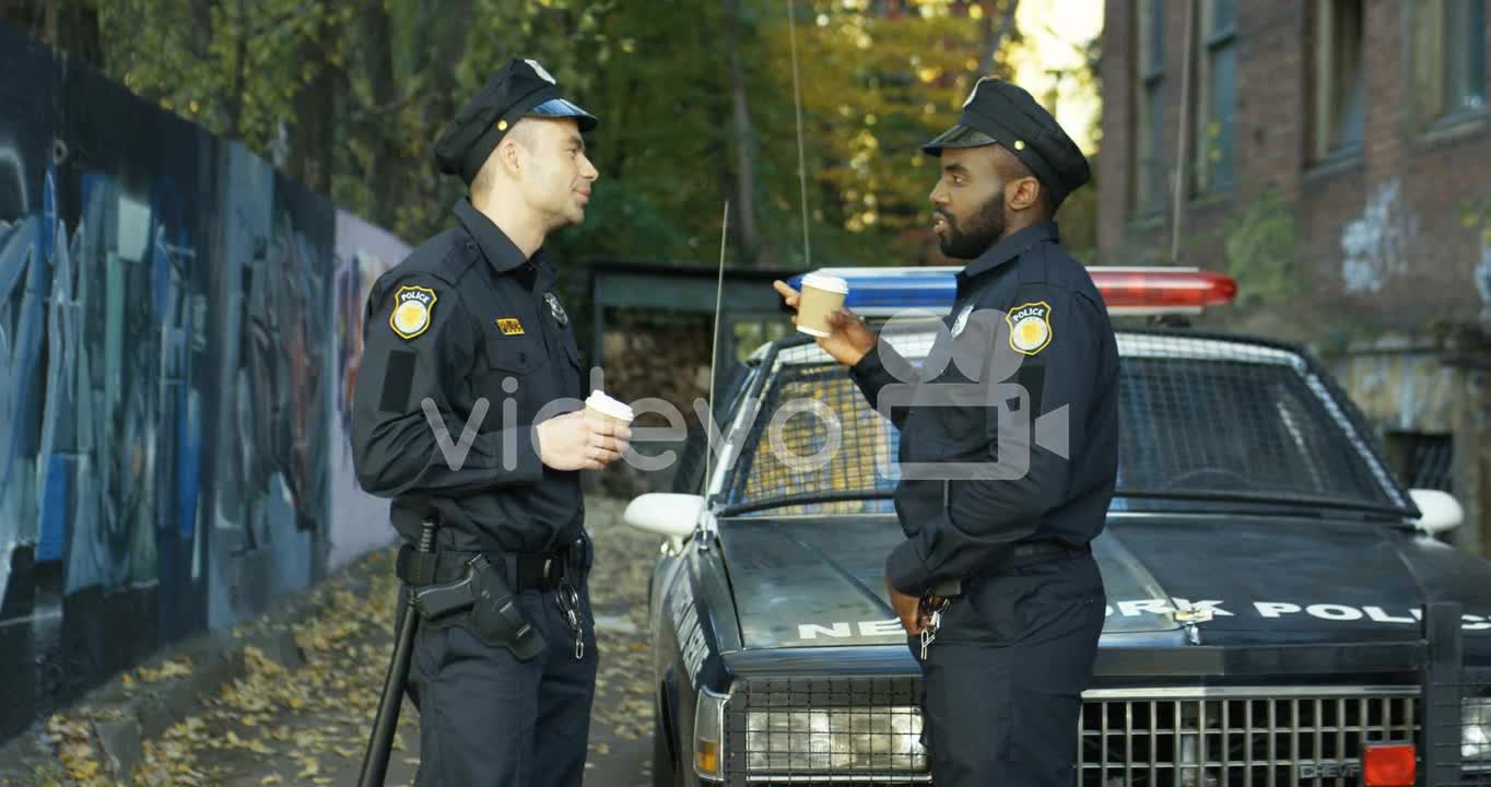 Multiethnic Policemen Resting Outdoors And Sipping Coffee To Go