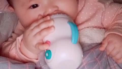 baby playing with formula bottle toys